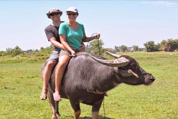 Tourists Enjoy Riding Buffalo In Countryside